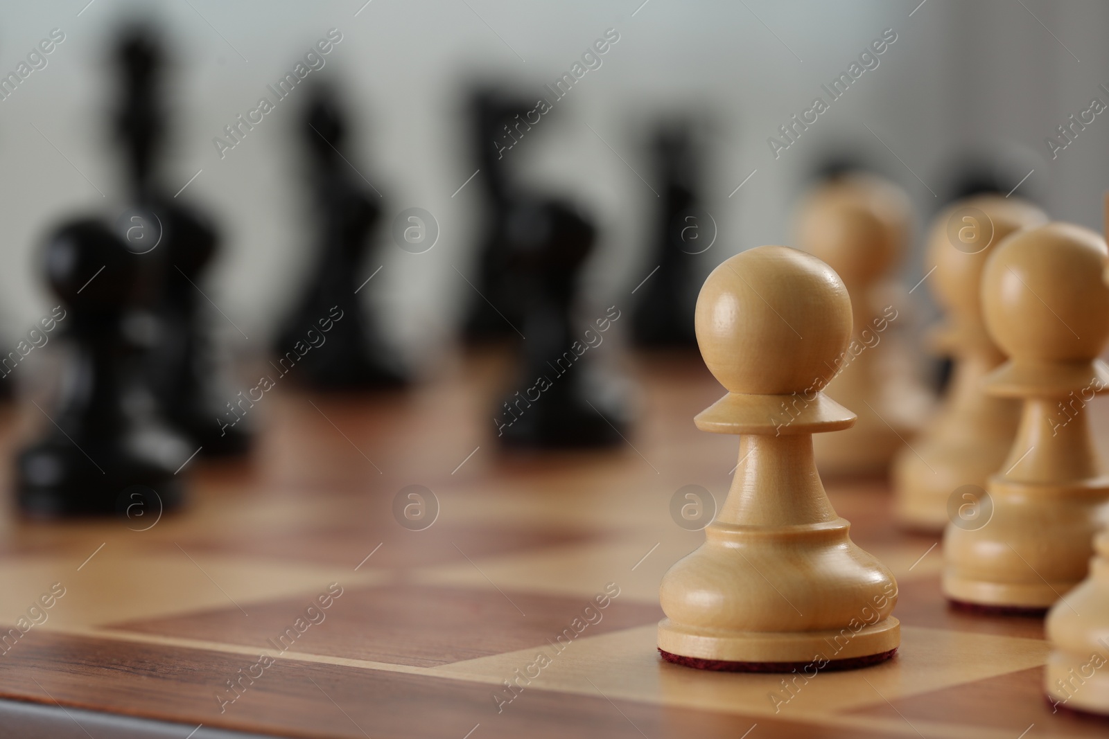 Photo of White wooden pawns on chess board, selective focus. Space for text