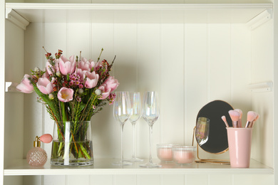 White shelving unit with glassware and different decorative elements