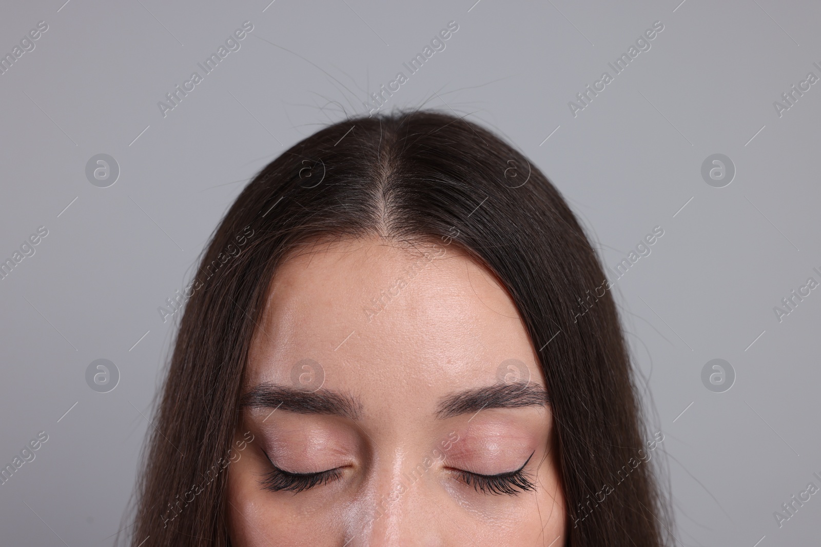 Photo of Woman with healthy hair on grey background, closeup