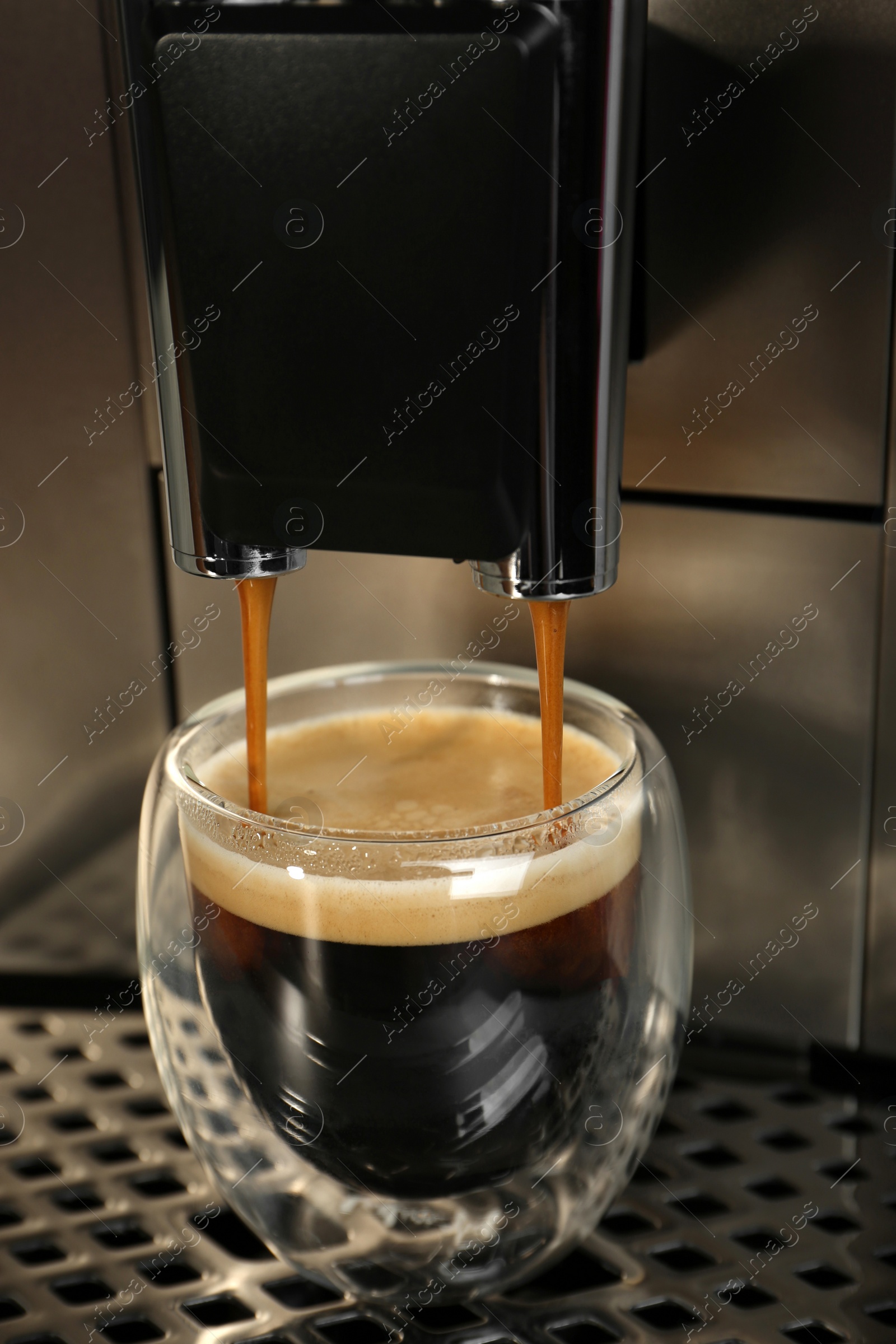 Photo of Espresso machine pouring coffee into glass, closeup