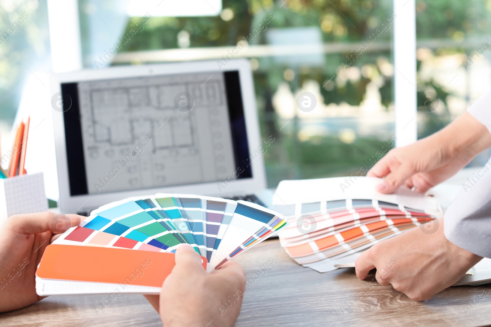 Photo of Team of designers working with color palettes at office table, closeup