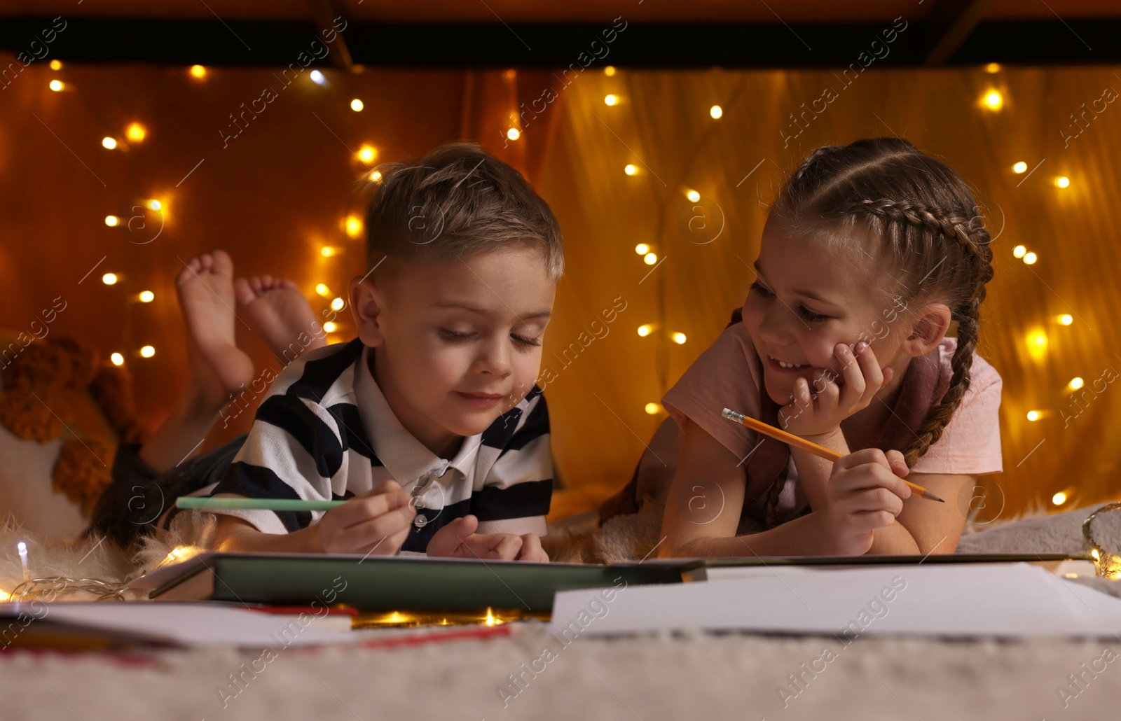 Photo of Children drawing in play tent at home