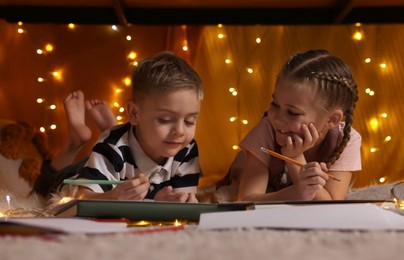 Photo of Children drawing in play tent at home