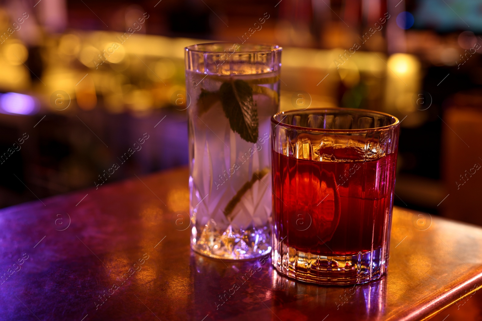 Photo of Fresh alcoholic cocktails on counter in bar. Space for text