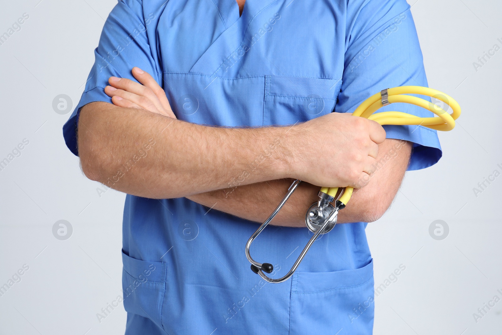 Photo of Medical assistant with stethoscope on color background, closeup