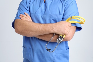 Medical assistant with stethoscope on color background, closeup