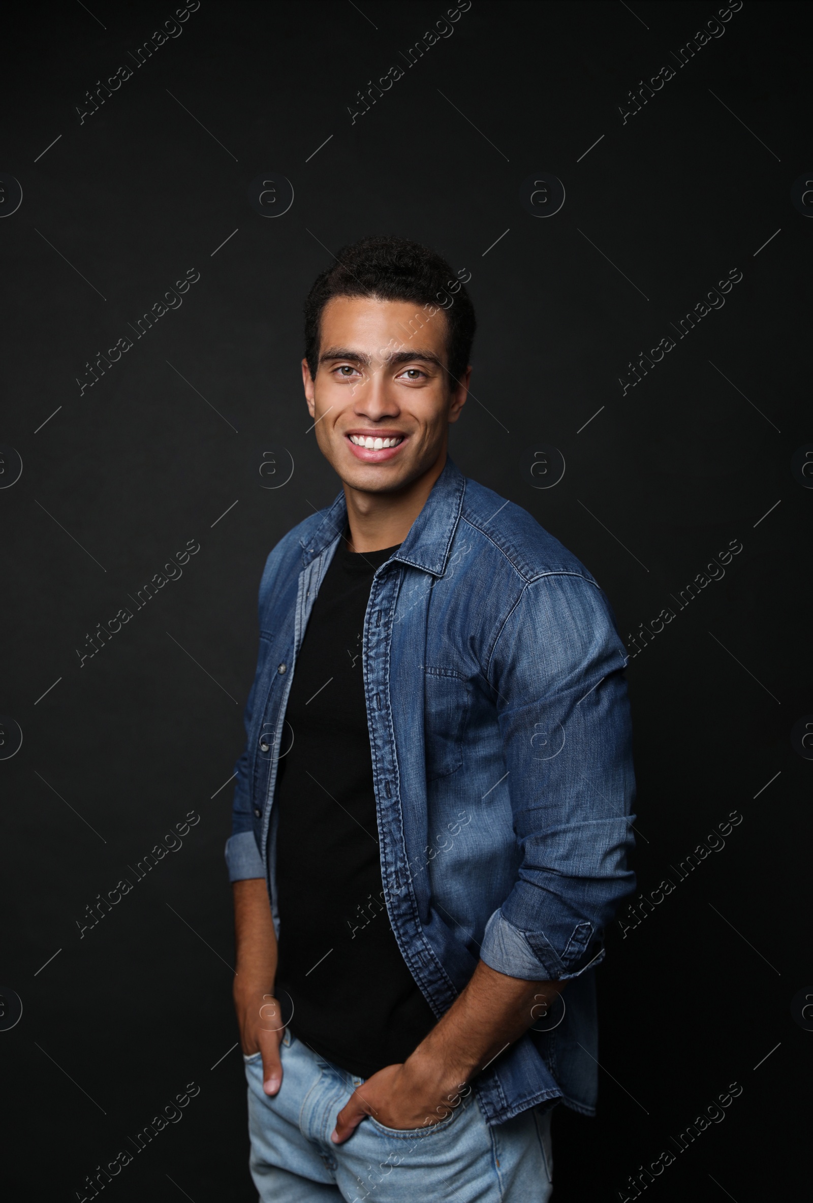 Photo of Handsome young African-American man on black background