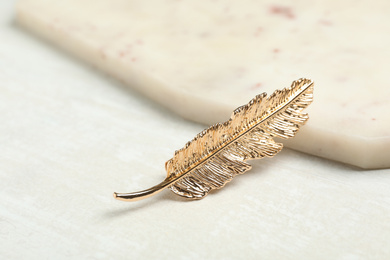 Photo of Beautiful gold hair clip on white table
