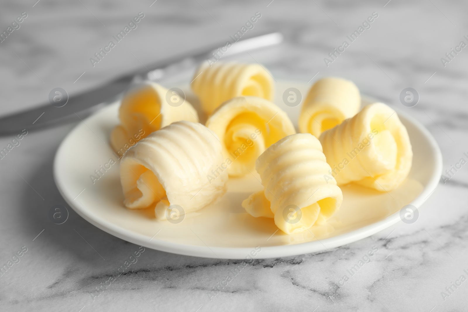 Photo of Plate with fresh butter curls on table