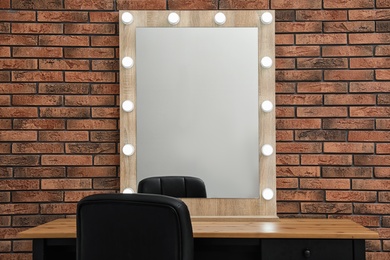 Photo of Makeup room interior with wooden table and large mirror