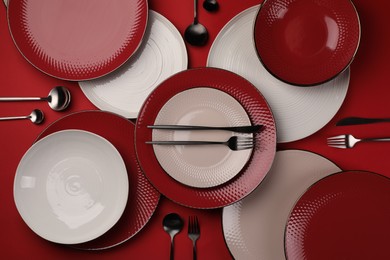 Photo of Stylish table setting with cutlery on red background, flat lay