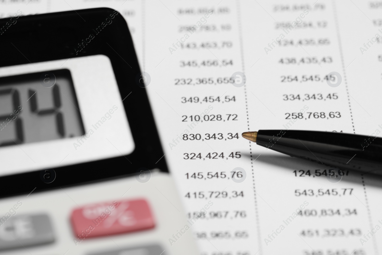 Photo of Calculator and pen on financial document, closeup