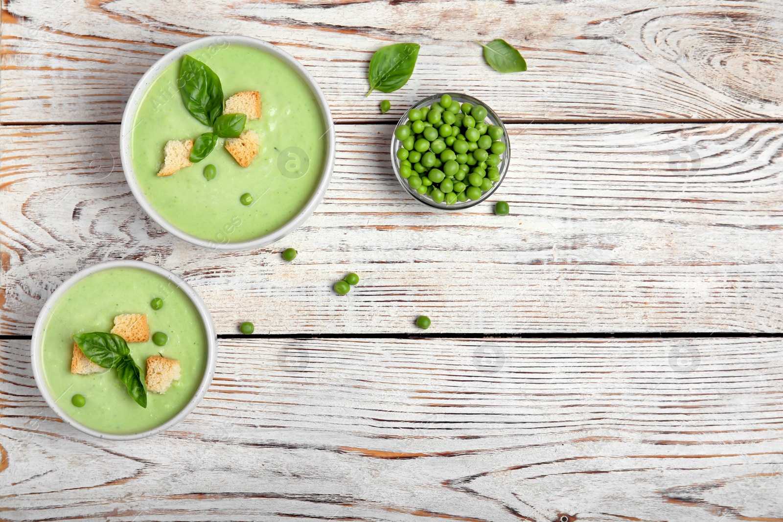 Photo of Flat lay composition with green pea soup on wooden background