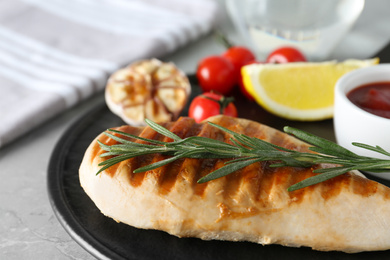 Delicious grilled chicken with vegetables and sauce on marble table, closeup