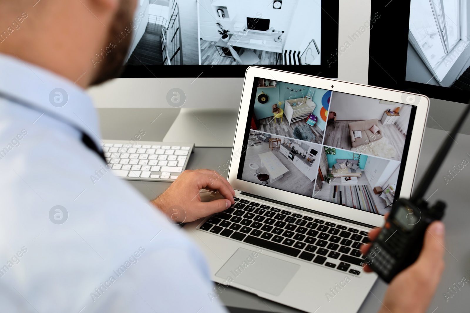 Photo of Male security guard with portable transmitter monitoring home cameras indoors, closeup