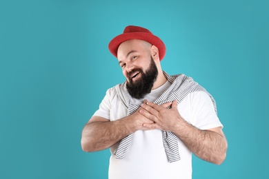 Photo of Portrait of man holding hands near heart on color background