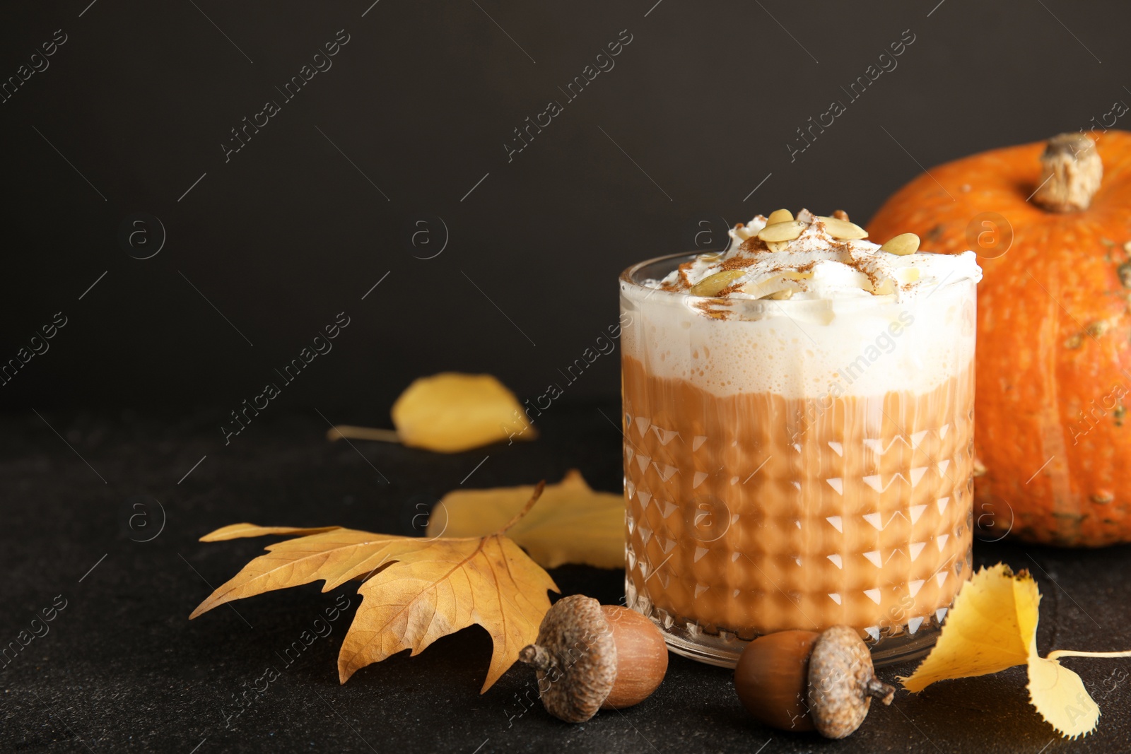 Photo of Composition with pumpkin spice latte in glass on table. Space for text