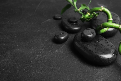 Photo of Zen stones and bamboo on dark background. Space for text