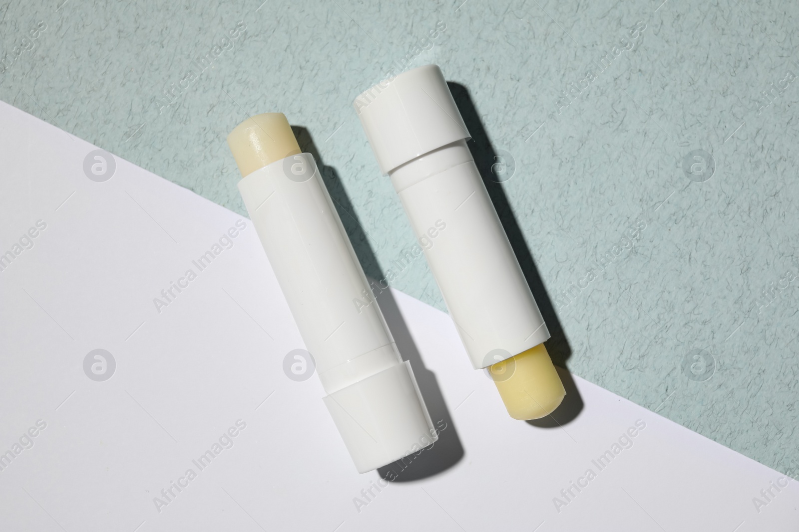 Photo of Hygienic lipsticks on color background, flat lay