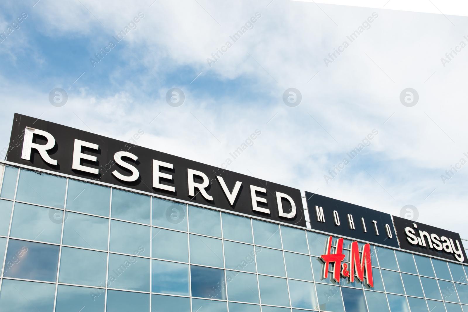 Photo of Warsaw, Poland - September 08, 2022: Shopping centre with many signs under cloudy sky