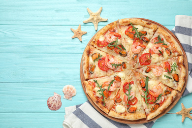 Delicious seafood pizza on light blue wooden table, flat lay. Space for text