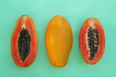 Photo of Fresh ripe papaya fruits on light turquoise background, flat lay