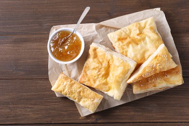 Delicious puff pastry served on wooden table, top view