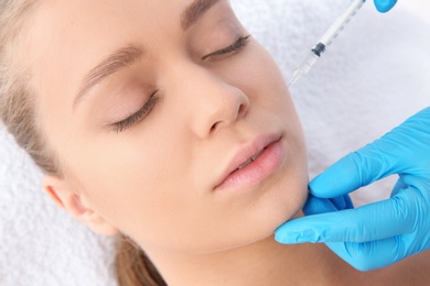 Photo of Young woman getting facial injection in clinic. Cosmetic surgery concept