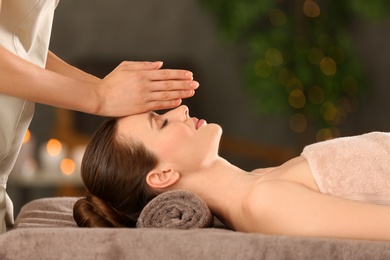 Photo of Beautiful young woman enjoying massage in spa salon