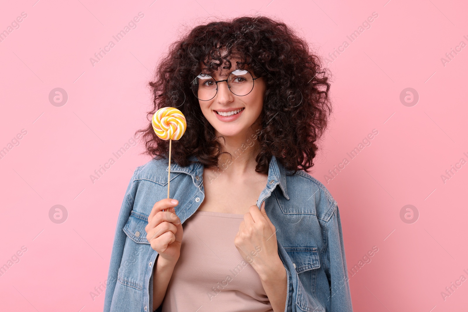 Photo of Beautiful woman with lollipop on pink background