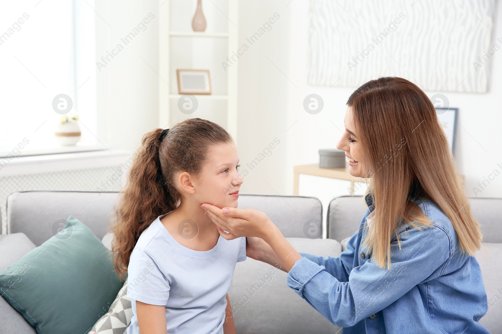 Photo of Young woman checking little girl's pulse indoors