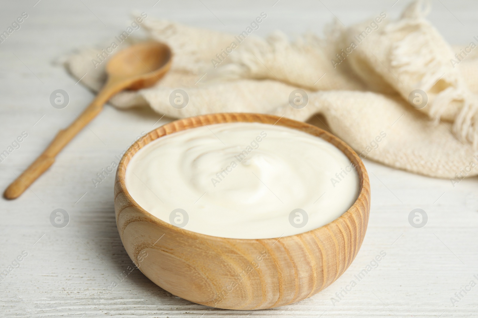 Photo of Tasty organic yogurt on white wooden table