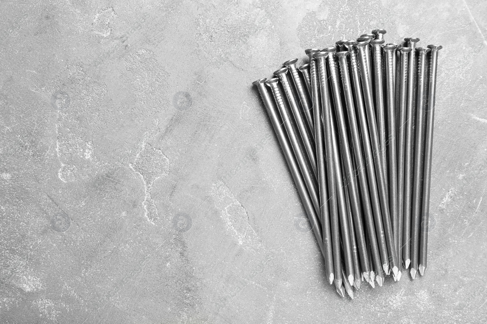 Photo of Many metal nails on grey background, flat lay. Space for text