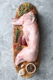 Photo of Whole raw rabbit, liver and spices on grey textured table, top view