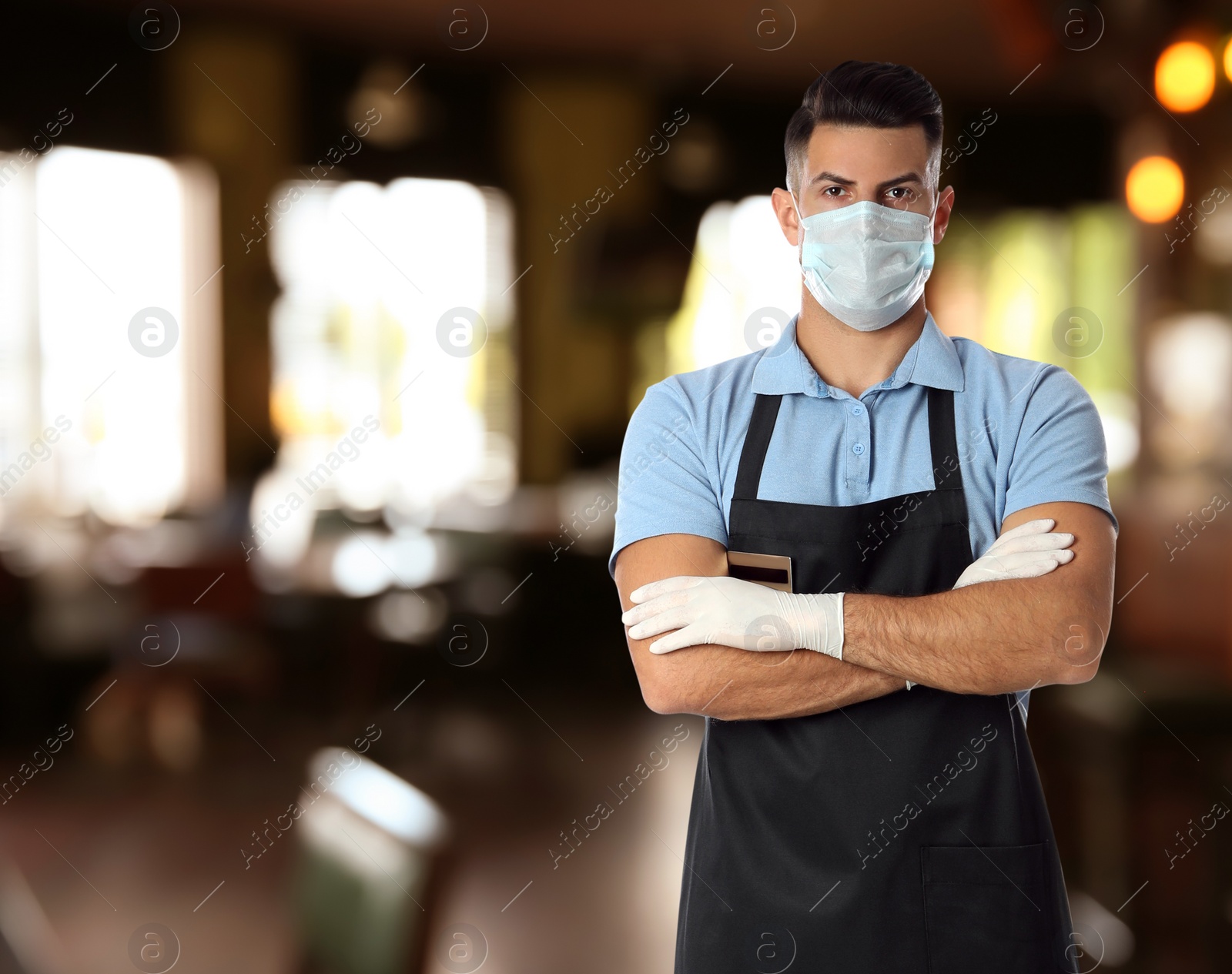 Image of Waiter in medical face mask in restaurant. Space for text