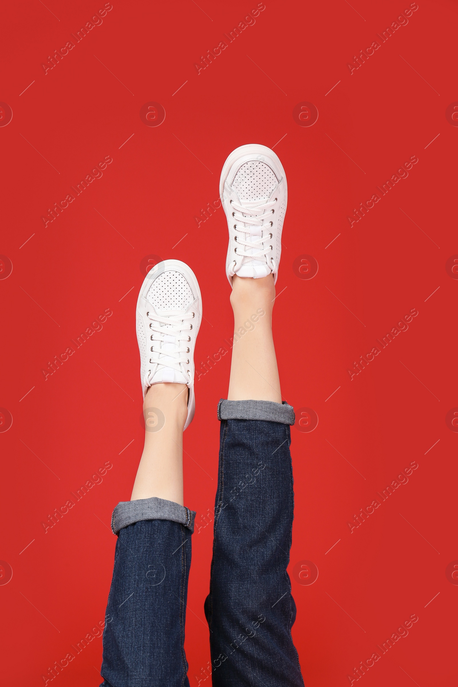 Photo of Woman in stylish sport shoes on color background