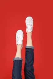 Photo of Woman in stylish sport shoes on color background