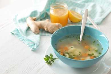 Bowl of fresh homemade soup to cure flu on wooden table