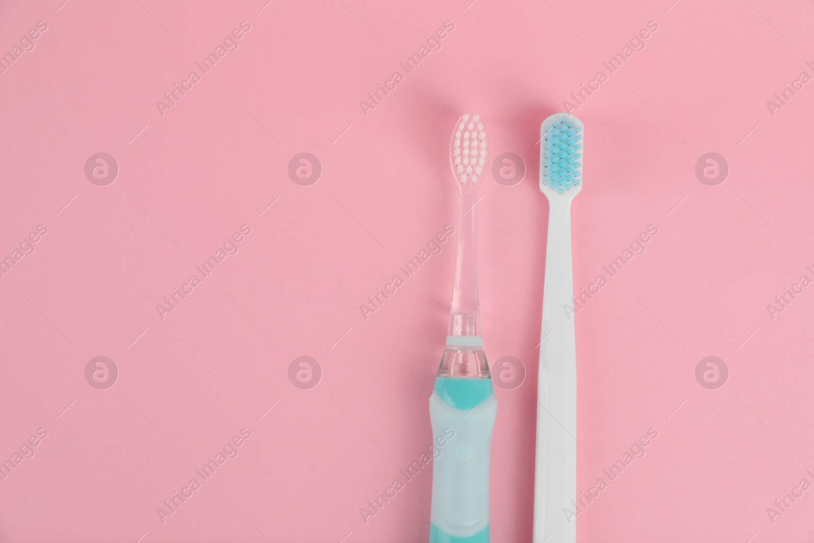 Photo of Electric and plastic toothbrushes on pink background, flat lay. Space for text