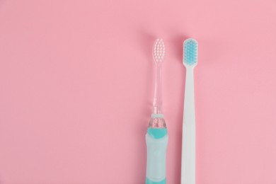 Photo of Electric and plastic toothbrushes on pink background, flat lay. Space for text