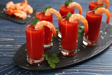 Photo of Shrimp cocktail with tomato sauce on blue wooden table