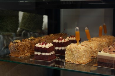 Different delicious desserts on counter in store