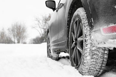 Photo of Snowy country road with car on winter day, closeup