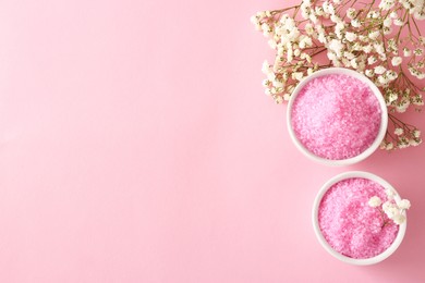 Photo of Aromatic sea salt and beautiful flowers on pink background, flat lay. Space for text