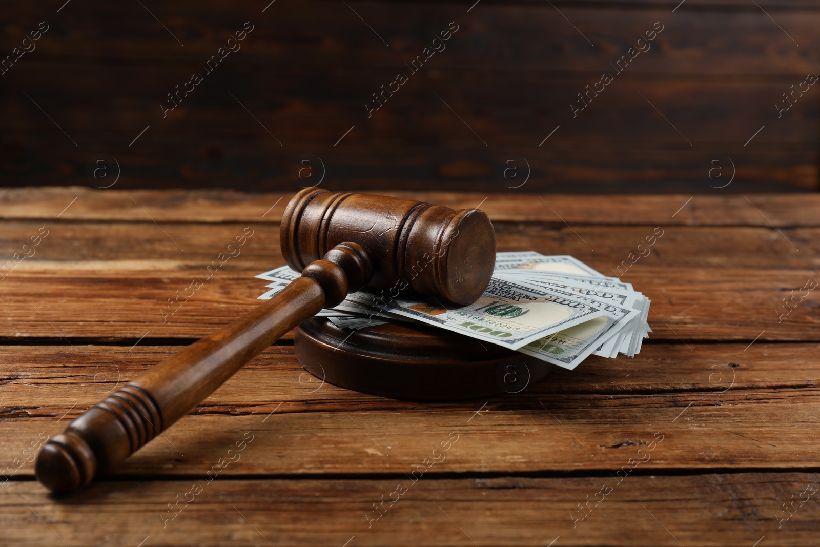 Photo of Judge's gavel and money on wooden table