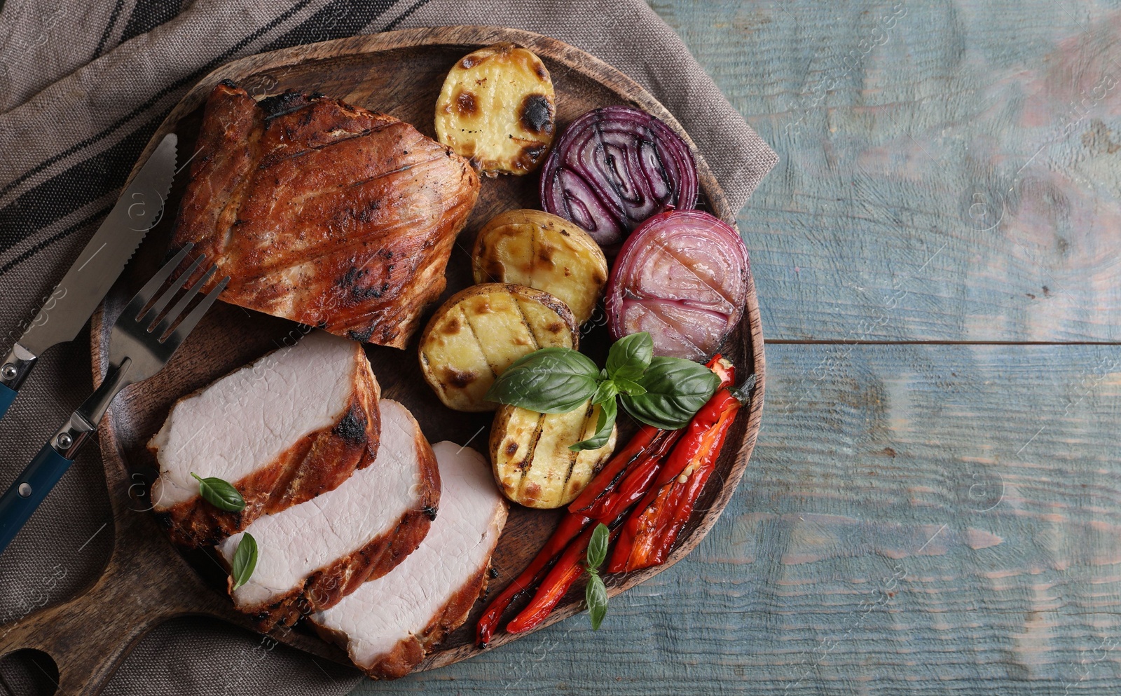 Photo of Delicious grilled meat and vegetables served on wooden table, top view. Space for text