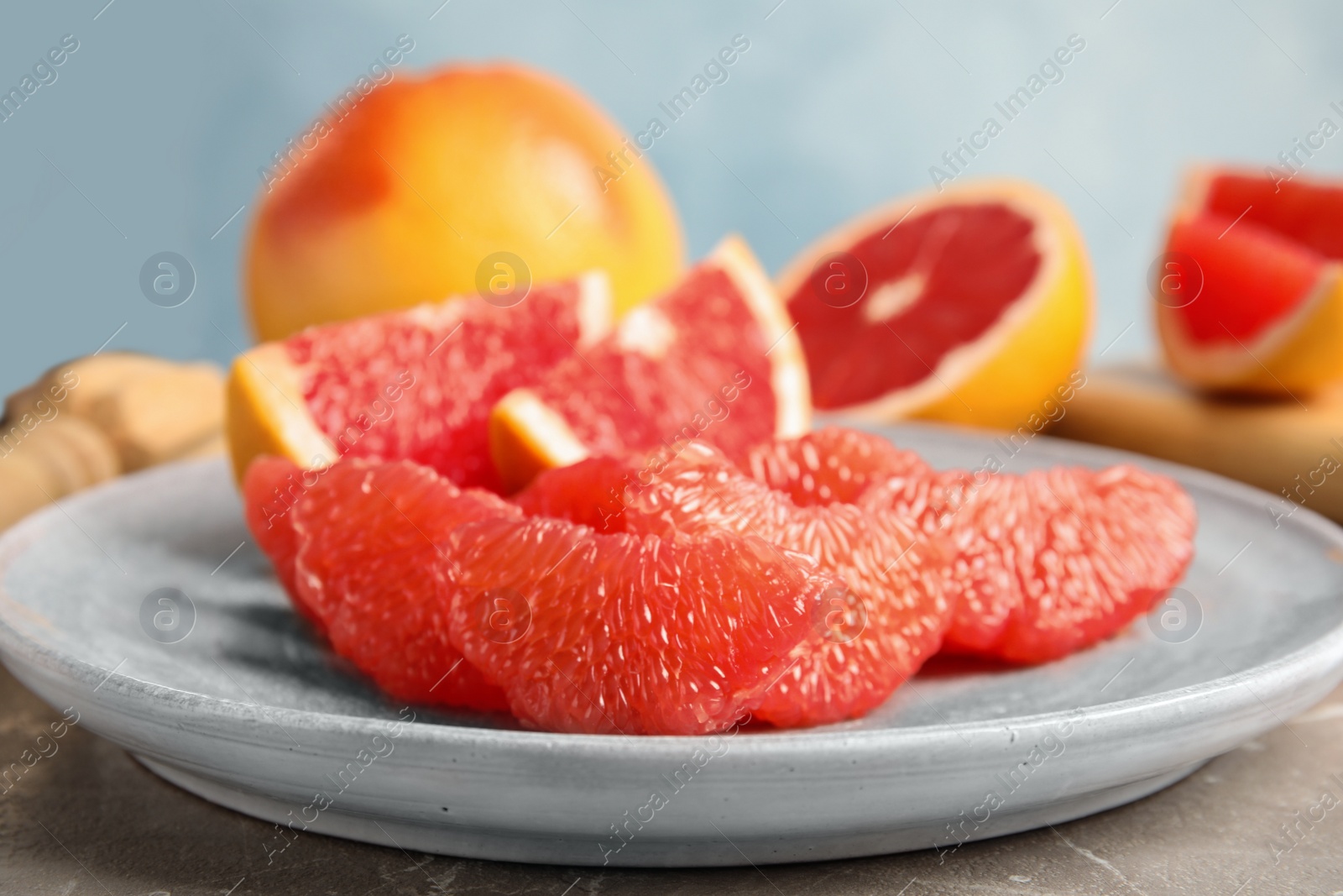 Photo of Plate with ripe grapefruit on table. Fresh fruit