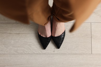 Photo of Businesswoman in leather shoes on floor, above view