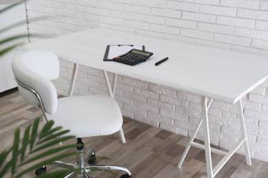 Photo of Comfortable workplace with office chair and wooden table