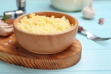 Photo of Bowl with mashed potatoes on wooden board